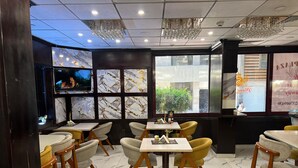 A restaurant interior with marble flooring, wooden chairs, and tables. - Salma Hotel (Giza)