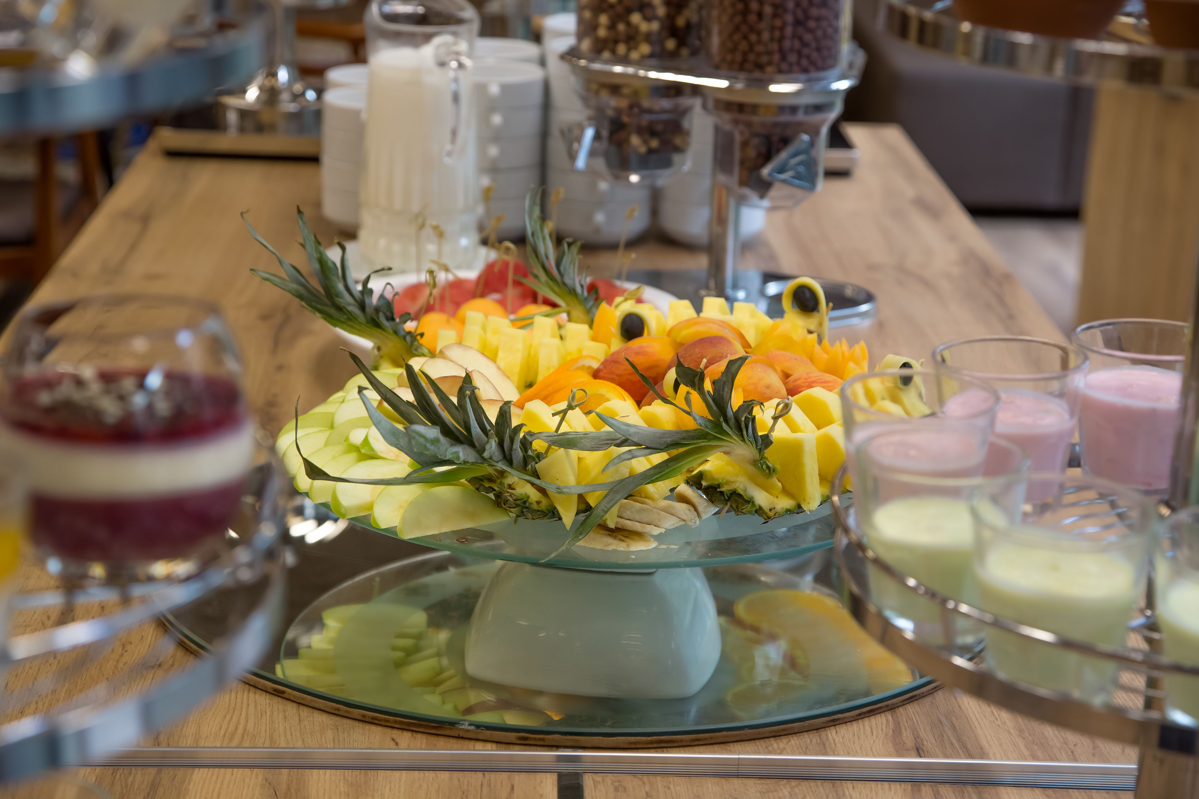 A buffet table with a variety of fruits and beverages.