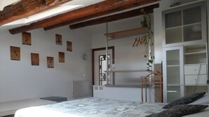 A bedroom with a bed, a wardrobe, a radiator, and wall art. - Maison Mare&Monti (Pesaro)