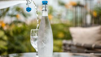 Una botella de agua con etiqueta, sobre una mesa al aire libre.