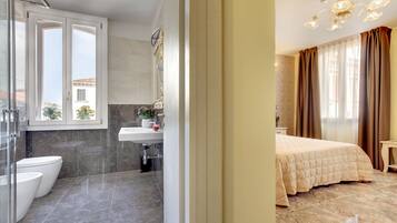 Een moderne badkamer met een douchecabine van glas, een witte wastafel en een toilet.