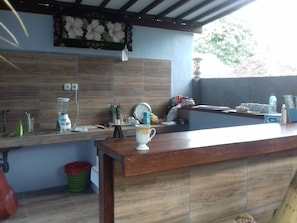 Kitchen area with a countertop, sink, and various kitchen items.