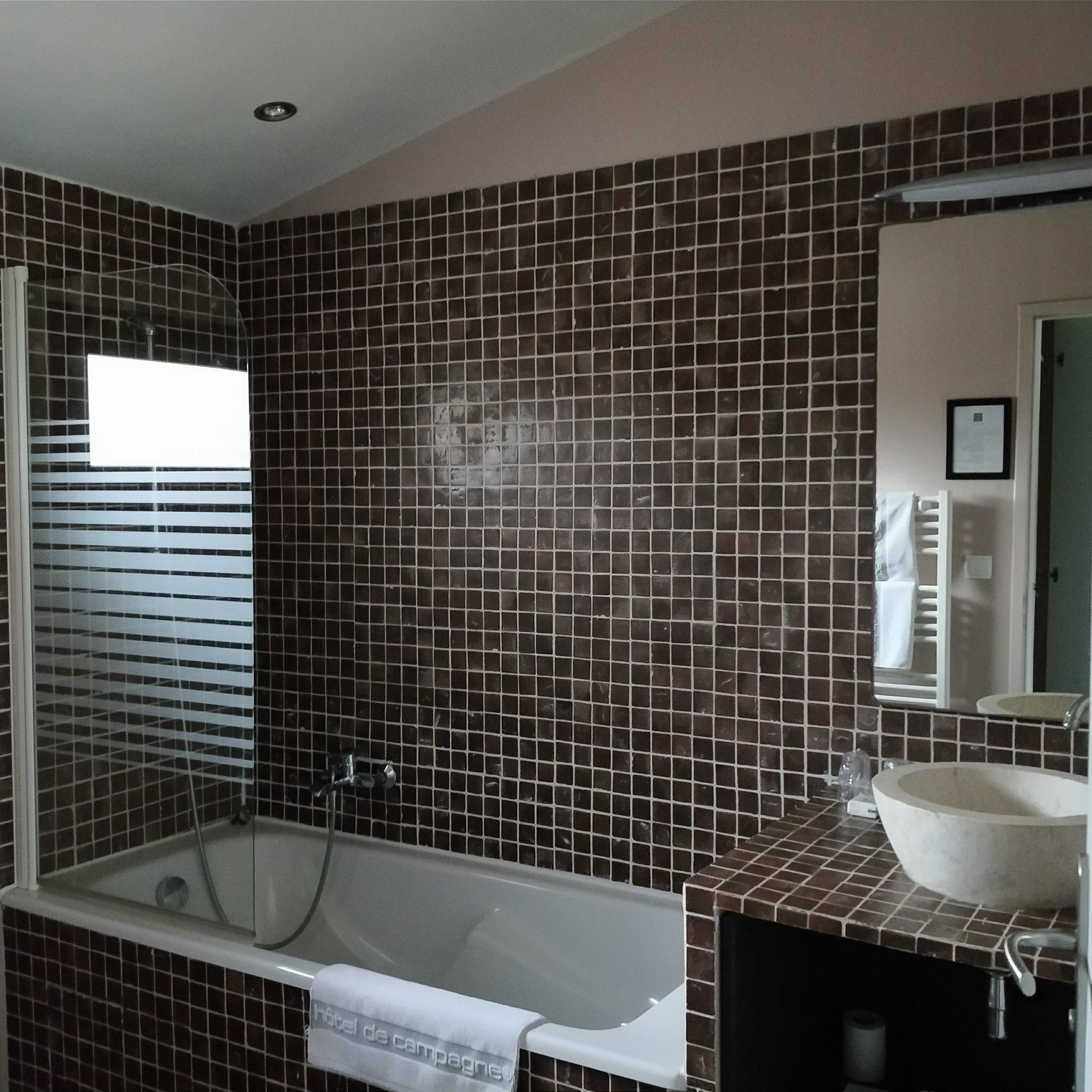 A bathroom with a bathtub, a sink, and a mirror.