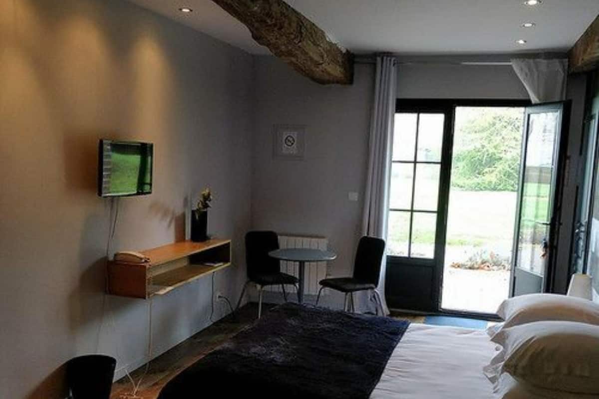 A bedroom with a large bed, a desk, and a chair.