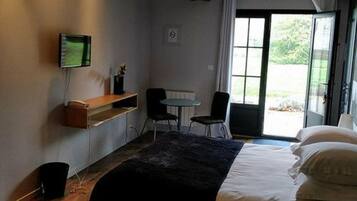 A bedroom with a large bed, a desk, and a chair.