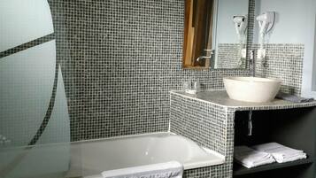 A bathroom with a bathtub, a sink, and a mirror.