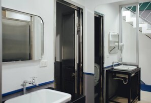 A bathroom with a white sink, a mirror, and a toilet.