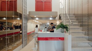 Cozinha moderna com bancada, banquetes e escada.