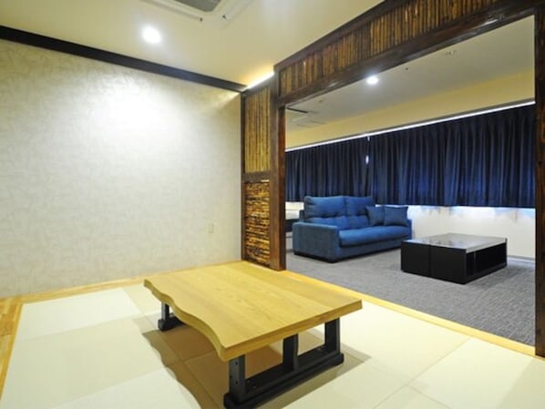 A room with a wooden table, a blue sofa, and a black coffee table.