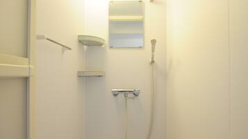 A bathroom with a shower, a towel rack, and a mirror.