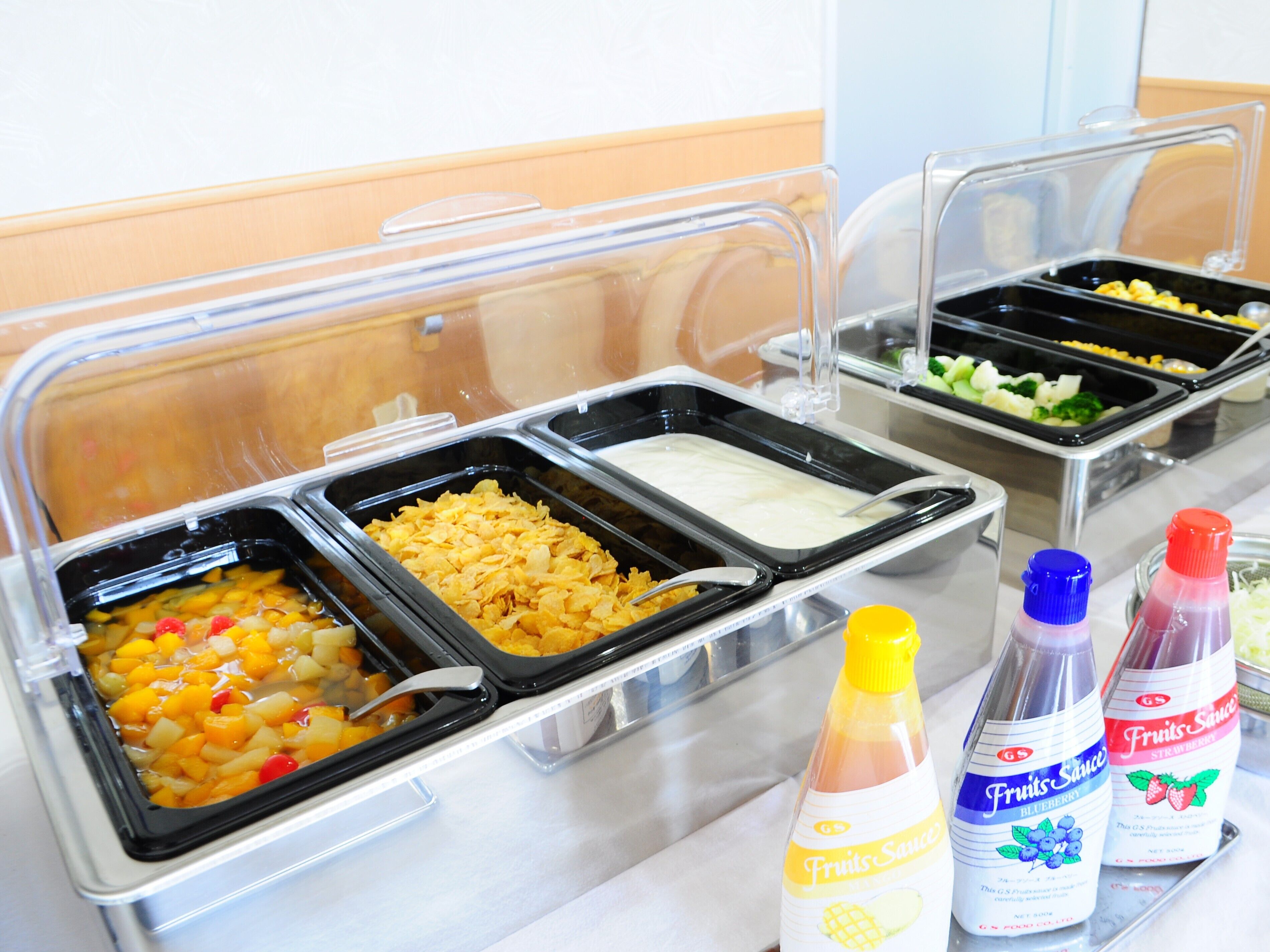 A buffet with various food options and condiments.