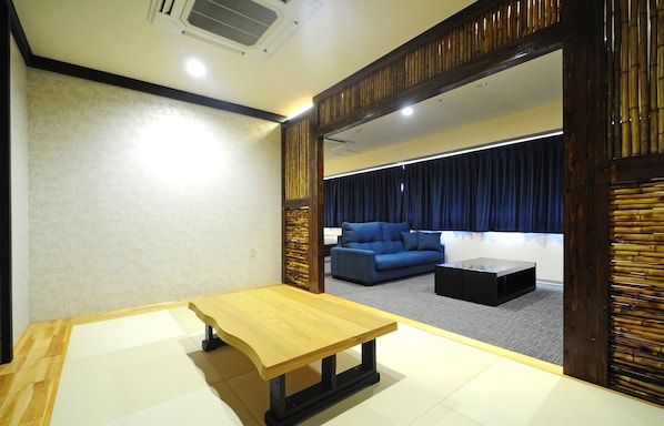 Una habitación con una mesa de madera, un sofá azul y una mesa baja color café oscuro.