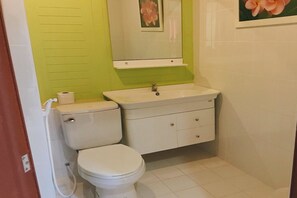 A small bathroom with a toilet, sink, and mirror. - Rung Arun Resort (Ko Pha-ngan)