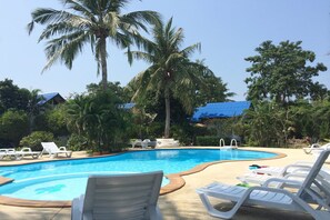A swimming pool with lounge chairs and palm trees. - Rung Arun Resort (Ko Pha-ngan)