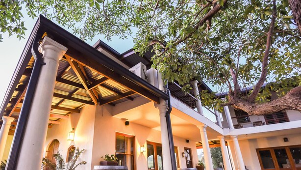 A building with a covered patio area, columns, and potted plants. - Lovane Boutique Wine Estate & Guesthouse (Stellenbosch)