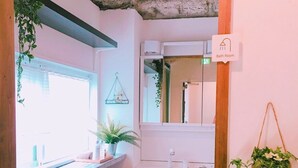 A bathroom with a sink, mirror, and a sign indicating it's the bathroom. - Osaka guesthouse RELASTAY (Osaka)