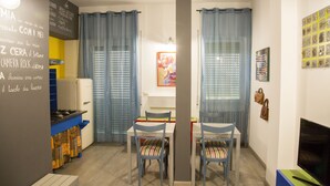 Un espace de vie compact comprenant une kitchenette, un coin repas et un téléviseur.