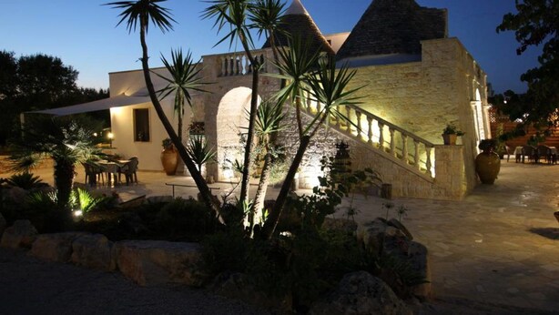 A stone building with a modern extension, featuring a staircase and outdoor seating area. - Agriturismo Grotta di Figazzano (Ostuni)