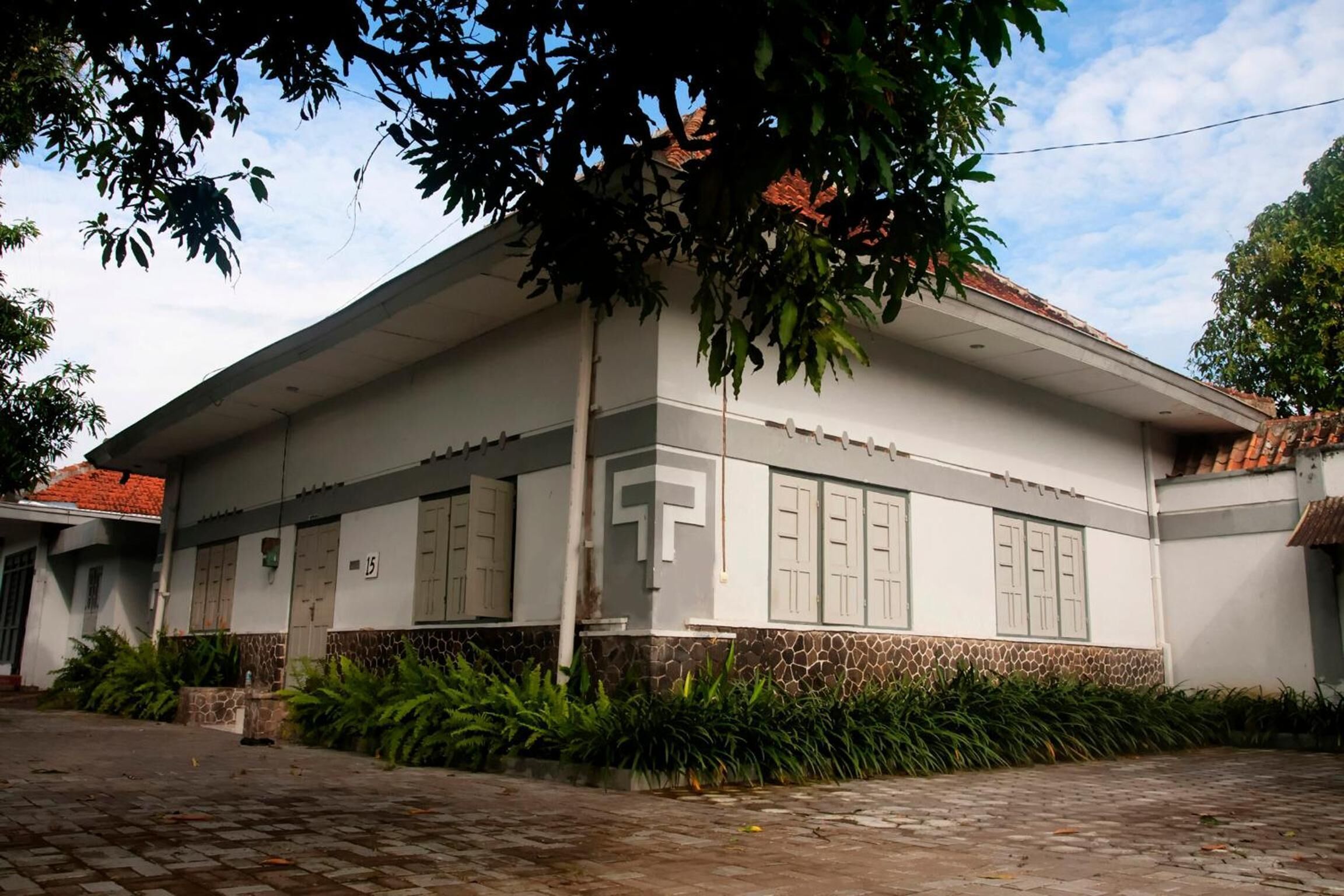 A two-story building with a flat roof, large windows, and a stone base.