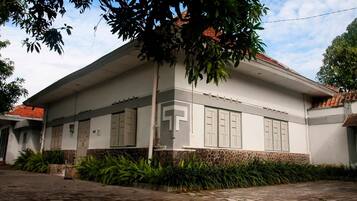 A two-story building with a flat roof, large windows, and a stone base.