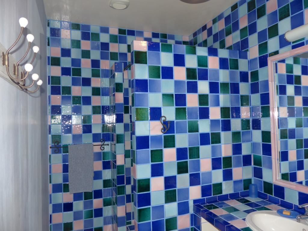 Une salle de bain avec un carrelage à motifs à carreaux, un lavabo et un miroir.