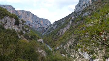 Un paysage montagneux caractérisé par des falaises rocheuses et une végétation luxuriante.