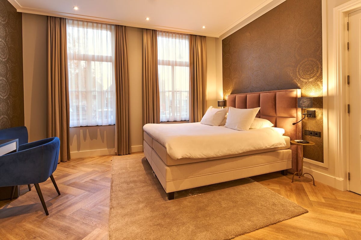 Un dormitorio con una cama grande, un escritorio y una silla.