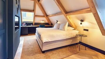 A bedroom with a bed, bedside table, and a desk with a chair.