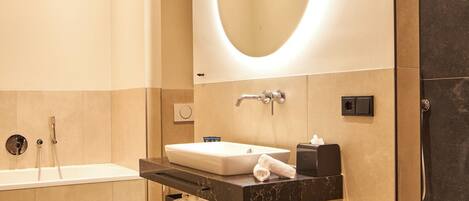 A modern bathroom with a bathtub, a sink with a mirror, and a towel rack.