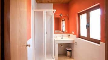 Un baño con un lavamanos blanco, un espejo y una ventana.
