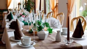 A dining table set with white tablecloth, clear glassware, and brown napkins. - Sporthotel Malchow (Malchow)