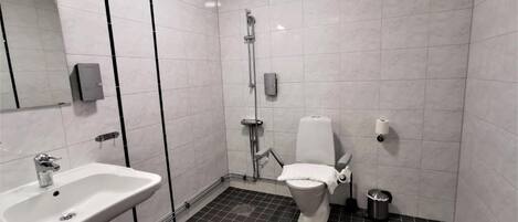A modern bathroom with a white sink, toilet, and shower.
