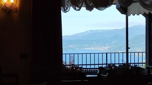 Comedor con vistas a un paisaje costero, que incluye montañas y una masa de agua.