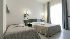 A hotel room with two beds, a nightstand, a phone, and a window with curtains. - Hotel Nobel (Rimini)