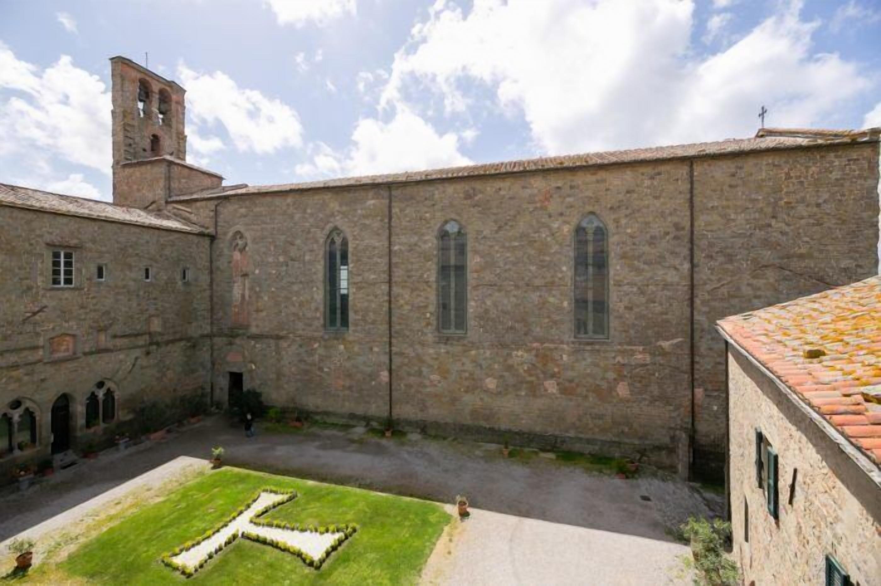 A stone building with arched windows and a bell tower.