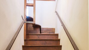 Una escalera de madera con barandillas a ambos lados, que sube a un piso superior.