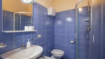 A bathroom with a sink, toilet, and shower.