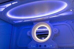 A futuristic room with a circular light fixture and control panel. - Nang Capsule Hostel (Da Nang)