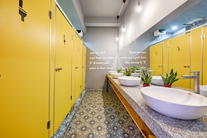 A bathroom with yellow lockers, a marble countertop, and a large mirror. - Nang Capsule Hostel (Da Nang)