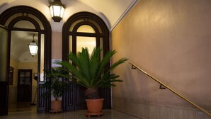 A grand entrance with a marble staircase, two large potted plants, and a handrail. - Chroma Italy - Chroma Deka (Rome)