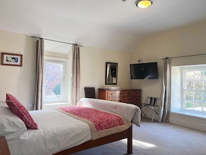 A bedroom with a bed, a dresser, a television, and a window. - The Crown Hotel (Corwen)