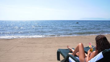 Playa privada, sillas reclinables de playa, sombrillas