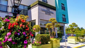 The Lordbagenal Hotel with a modern facade, large windows, and a well-maintained garden with colorful flowers and neatly trimmed bushes. - Lord Bagenal Inn (Leighlinbridge)