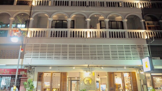 A multi-story building with balconies, a shop on the ground floor, and a sign indicating a business. - Karnvela Phuket (Phuket)
