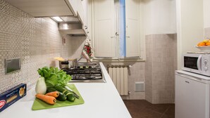 A kitchen with patterned tiles, a stove, a microwave, and a box of spaghetti. - Charming Suite Cavour Heart of Florence (Florence)