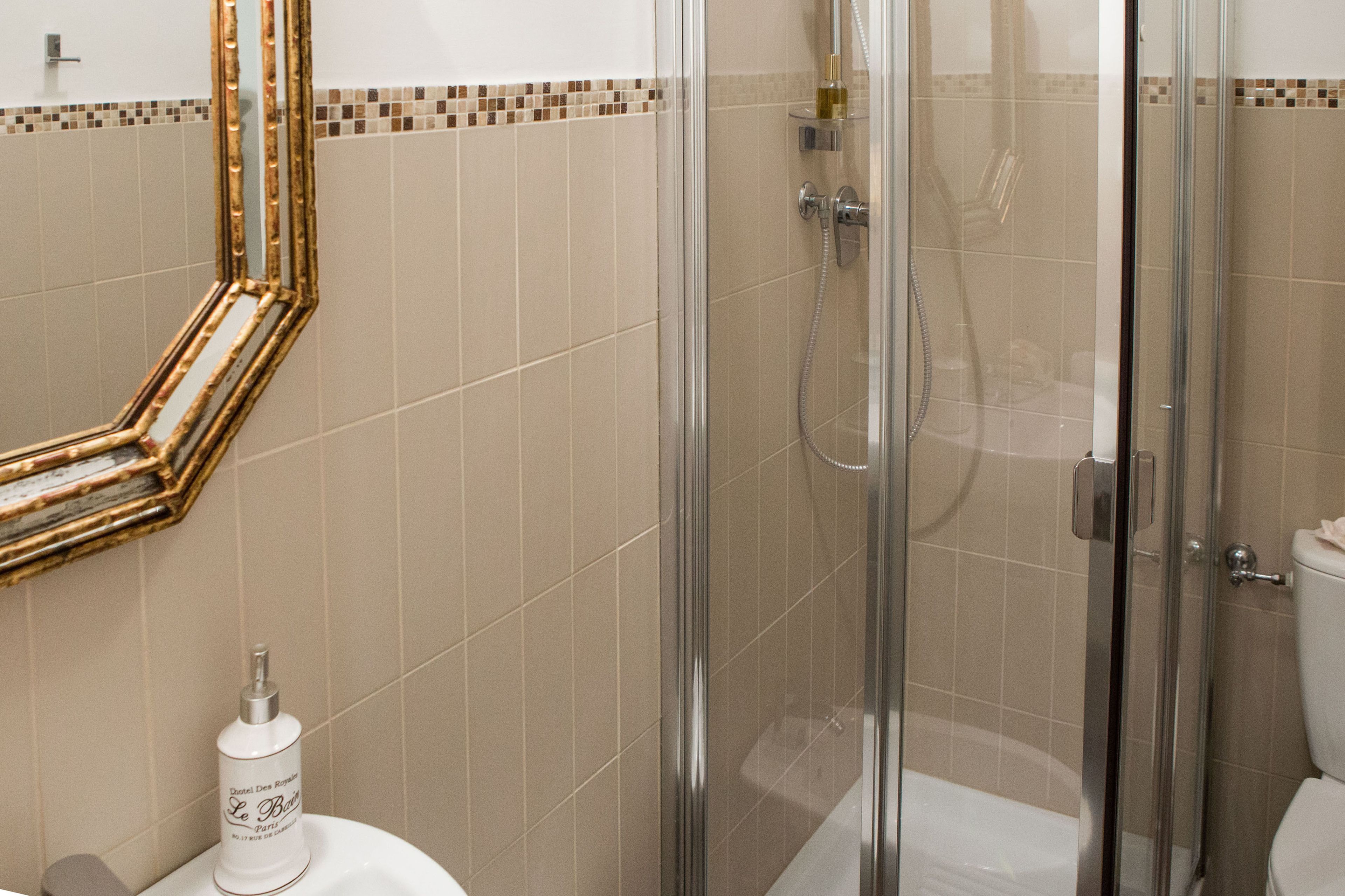Une salle de bain avec une douche à parois de verre, des toilettes et un lavabo.
