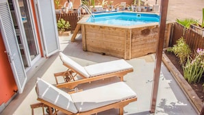 A wooden hot tub with a pool, two sun loungers, and a small garden area with plants. - Antonio Sousa Beach 3 Bedroom Apartment (Sal)