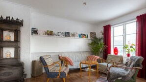 A cozy living room with a vintage sofa, a small table, and a dog standing on a chair. - Villa Bro (Brastad)