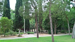 A park with a paved walkway, trees, and benches. - La Dimora di Vesta (Lecce)
