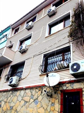 Edifício com vários andares e aparelhos de ar condicionado fixados nas paredes externas.